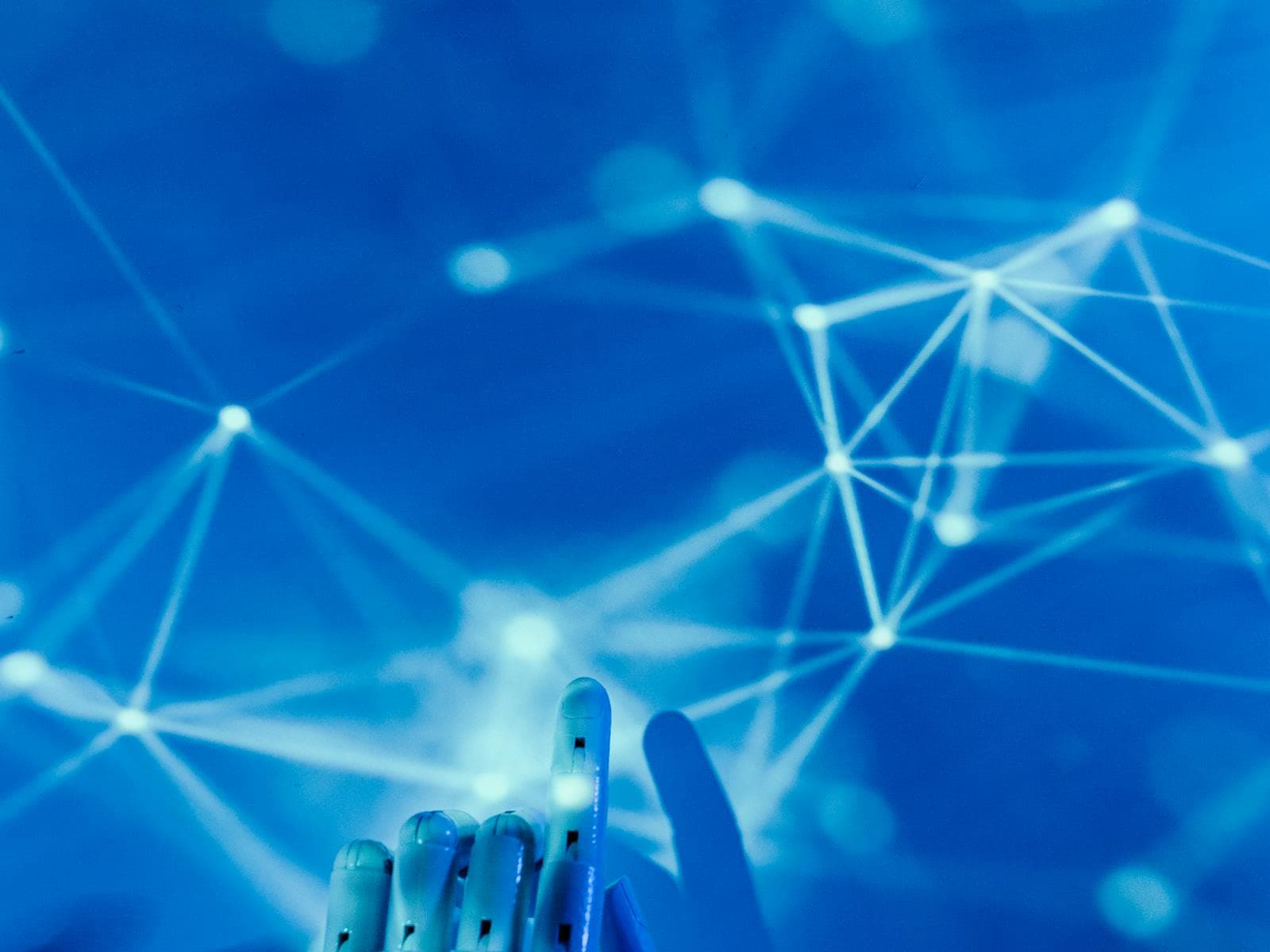 Robotic hand connected to a network of nodes representing artificial intelligence.